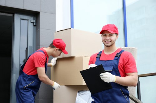 Professional movers carrying furniture through a Pimlico property